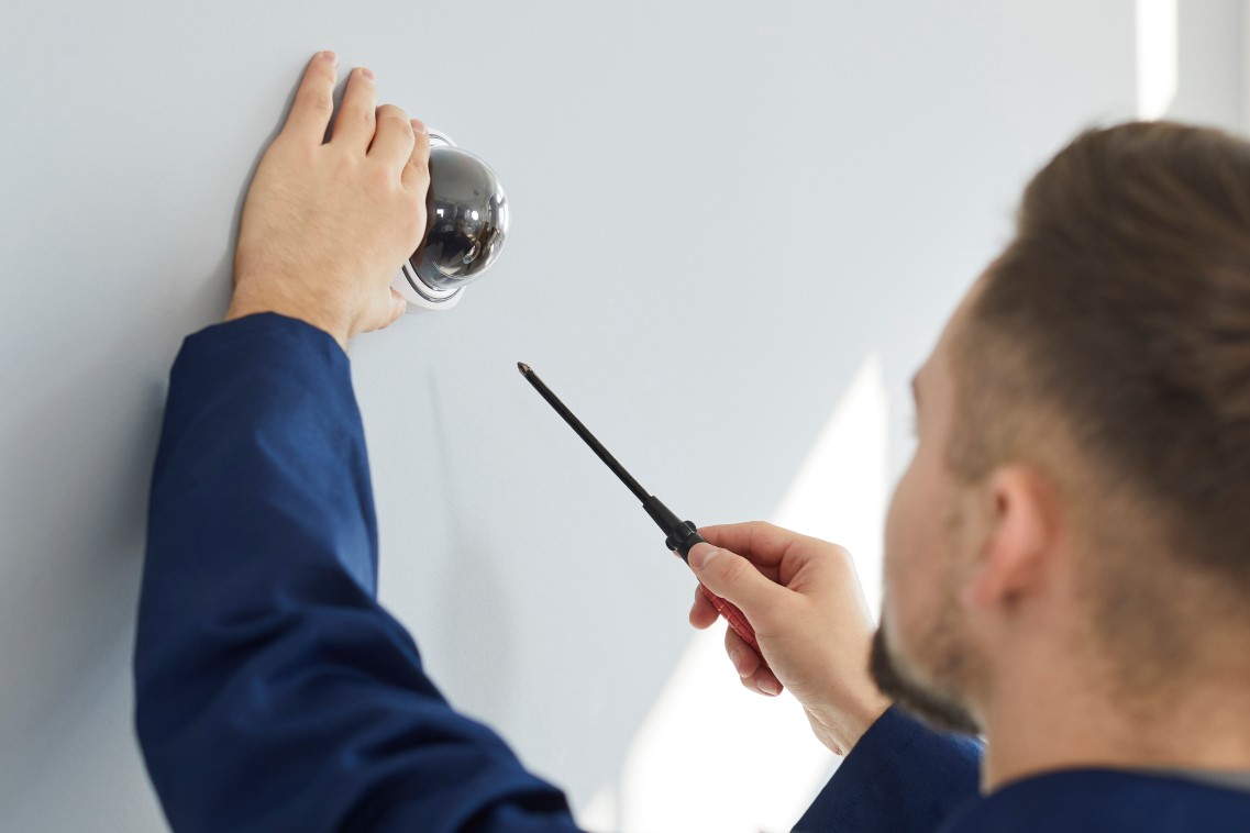 Man installing intrusion detection system in a commercial building
