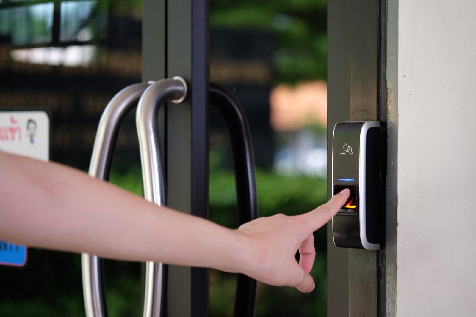 An employee uses a fingerprint recognition scanner to validate what time she arrives at work.