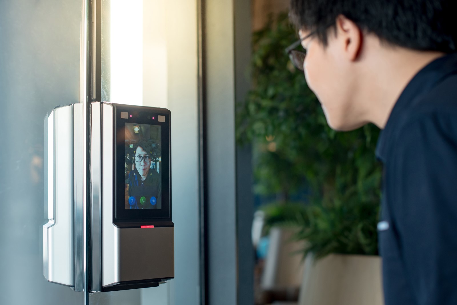 As part of a company’s biometric access control system, a biometric control device scans an employee’s face for recognition before allowing him entry.